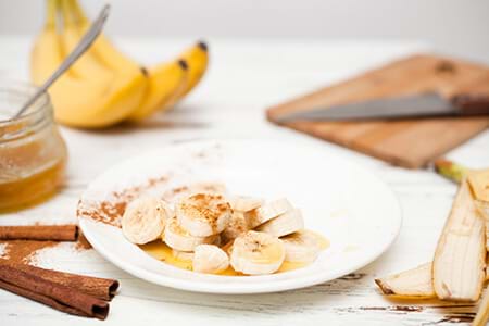 Bananas and honey as natural sweeteners on white wooden table. bananas and honey as natural sweeteners