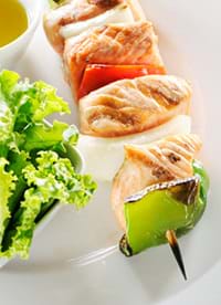 A salmon and vegetable shish kabob on a plate for a healthy meal. salmon and vegetable shish kabob