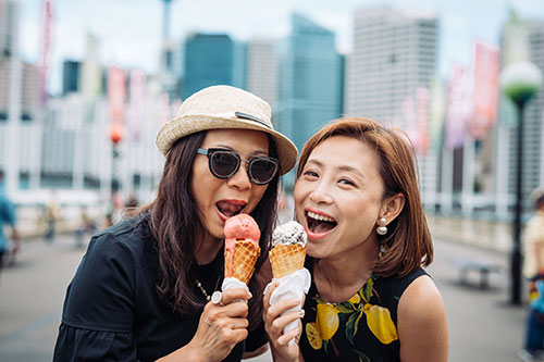 Two women enjoying eating ice cream on special day together. two women enjoying ice cream together