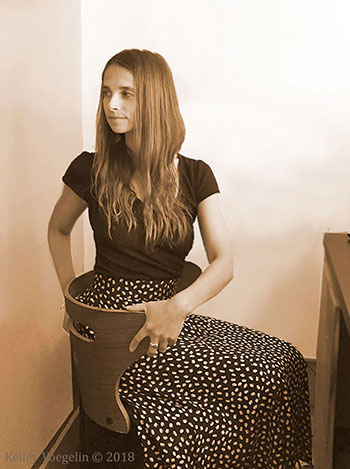 Woman doing a spinal twist yoga pose at desk Woman doing a spinal twist yoga pose