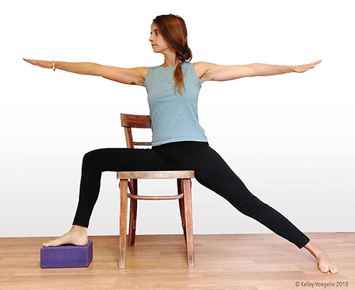 Warrior 2 yoga pose can be modified for people with limited mobility. woman doing warrior 2 yoga pose modification in chair