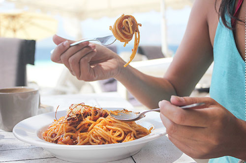 When you crave spaghetti, it might mean you have an allergic sensitivity to it. woman eating a bowl of spaghetti