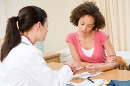 Woman Going Over Test Results With Doctor