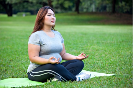 Woman in comfortable clothing practicing yoga in park woman practicing yoga in park
