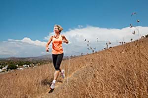 A woman running down a trail to release anger. woman running down a trail